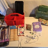 Overview of all art supplies including baskets, brushes, pencils, glue gun, clothespins, towel and beads