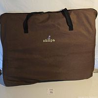 Brown zipper storage bag for the Zampa pet playpen with handles and the Zampa logo embroidered in the center.