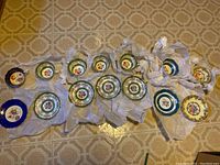 All 7 tea cup and saucer sets of various colors and patterns laid out on floor showing multiple brands and color variations.