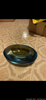 Image of blue sculpted crystal ashtray showing top view and yellow inset center
