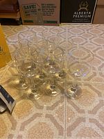 Photo showing the set of eight wine glasses arranged on patterned floor.