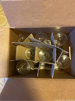 Top view of 7 clear wine glasses packed in a dividers box for protection.