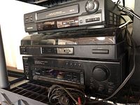 Stacked view of Samsung VHS VCR, Pioneer turntable with dust cover, and Sony receiver with cables.