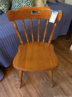 Front view of wooden barrel back side chair showing spindled back, contoured seat, and rounded legs.