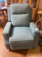 Front view of blue woven fabric electric recliner chair showing cushioned seat, armrests and backrest.