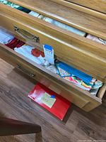 Opened wooden drawers showing folded kitchen linens including various towels and tablecloths.