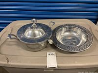 Wilton pewter covered serving bowl with lid, ladle, and decorative pewter bowl on a plastic surface.