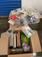 Wide view of packed box showing paper packs, ribbons, containers of embellishments, and other supplies