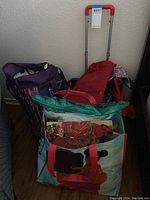 Overview of various totes and rolling tote with handle against wall