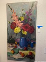 Front view of floral themed painting on canvas including blue pitcher with flowers and table still life.