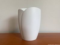 Full side view of the white bisque Kaiser vase showing smooth and ribbed surfaces and its height.