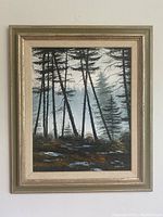 Full view of framed oil painting showing forest scene with fog and autumn ground cover, light gold-tone frame with fabric matting.