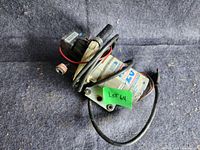 Photo of full pump showing attached wires, mounting bracket, and pressure switch with range label.