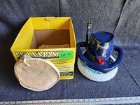 Blue Waxmaster electric polisher with yellow box, polishing bonnet, and polishing cloths seen.
