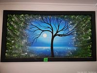 Full view of the framed acrylic painting showing the tree silhouette, blue sky and textured greenery.