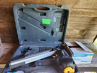 Mastercraft framing nailer in black carrying case with open lid and box of nails on table.