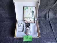 Digital muscle stimulating therapy machine with electrode pads and manual inside original box.