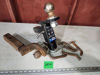 Adjustable height trailer hitch receiver with attached 2-inch ball hitch showing rust and wear on metal surfaces, pins and latch hardware included.