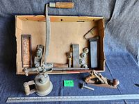 Wide shot showing all items arranged inside cardboard box and on fabric background