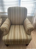 Front view showing the full armchair with striped fabric and padded arms and seat.