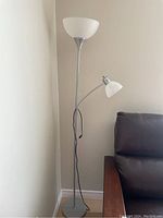 Full view of the metal floor lamp with two white plastic shades showing height and overall design.