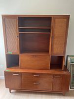 Full view of the wood wall unit showing upper and bottom sections with doors, shelves, and drawers.
