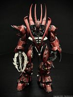 Front view of red and black cybernetic Spawn figure with prominent spikes on back and claw weapon on left arm.