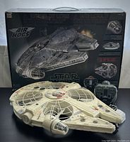 Photo of the Millennium Falcon quadcopter drone with box and remote control visible behind the model.
