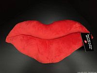 Front angle view showing soft bright red lips plush with attached tag.