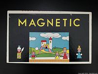 Closed view of vintage magnetic play theater box showing stylized child and castle illustrations on black background