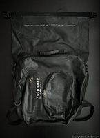 Front view of the black Zulupack waterproof backpack showing top handle, front zippered compartments, and adjustable shoulder straps.