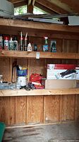Overview of shed shelves showing jack box, spray cans, tools and accessories