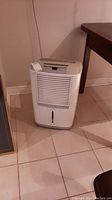 Front view of white Frigidaire dehumidifier with air vents and water level indicator on front panel.