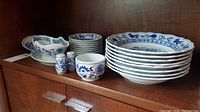 Full lot on shelf showing plates, bowls, gravy boat and salt and pepper shakers