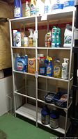 Front view of the metal shelving unit showing items on shelves for scale but contents not included in lot.