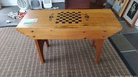 Bench top view showing chess board painted with black squares and card suit decorations.