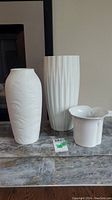 Photo of three white German vases, showing overall set and relative sizes.