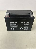 Front view of black rectangular 12V rechargeable sealed lead acid battery with terminal posts and labeling.