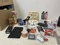 Overview of assorted household items including prank chip canister, Fitbit watch bands, alarm clock, decorative plaque, black sheath and keychains