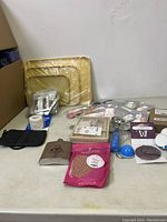 Photo showing large wax melt trays, black metal melter, replacement wicks, and various other small wax melt accessories.