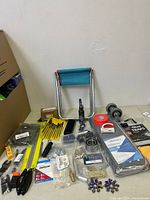 Photo showing small folding stool, files set, clamps, and packaged hardware components
