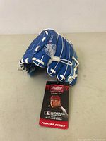 Front view of blue baseball glove with white lacing and MLB Authentic Collection tag.