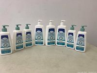 Seven bottles of TENA Proskin Body Wash and Shampoo lined up, showing front labels and pump tops.