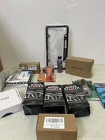 Overview photo showing multiple automotive and tool items including license plate frame, G-Sunny box, Sprayon bottle, wheel scratch kits, and TARO box.