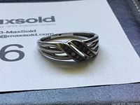 Front view of the 10k gold ring showing the crisscross gemstone setting and split band design.