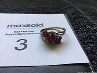 Ring placed on a MaxSold card showing the ring and rubies clearly.