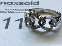 Close-up front angle of 925 sterling silver ring with heart motifs and small stones