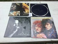 Front covers of four vinyl records showing different album art including colorful and black and white designs.