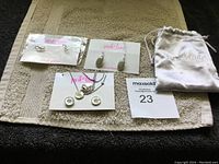 Three sets of earrings and one necklace set from Park Lane jewelry displayed on a towel with a Park Lane jewelry pouch.