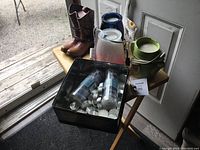 View of the lot on small table near door including wax warmers, cowboy boot candle holders, and tin with tea light candles.